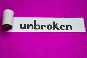 Unbroken text, Inspiration, Motivation and business concept on purple torn paper photo