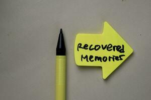 Recovered Memories write on sticky notes isolated on office desk. photo