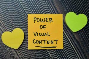 Power of Visual Content write on sticky notes isolated on office desk. photo