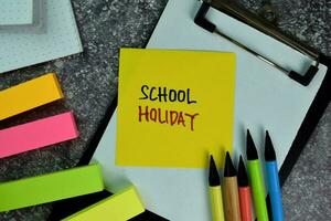 School Holiday write on sticky notes on the table. Education concept photo