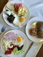 Lunch. Plates of eggs, ham, cheese and vegetables on table. Studio Photo