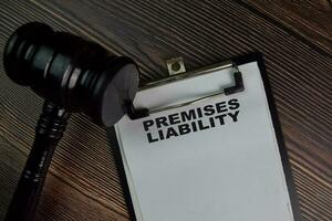 Premises Liability write on a paperwork isolated on Wooden Table. photo