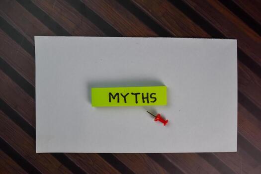 Myths write on sticky notes isolated on Wooden Table. photo