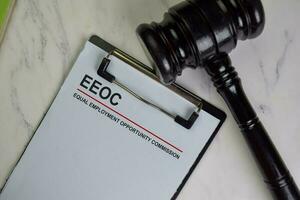 EEOC - Equal Employment Opportunity Commission write on a paperwork isolated on Wooden Table. photo