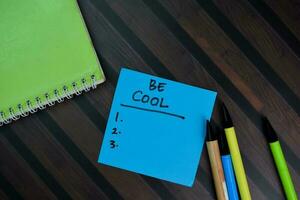 Be Cool write on sticky notes and supported by additional services isolated on Wooden Table. photo