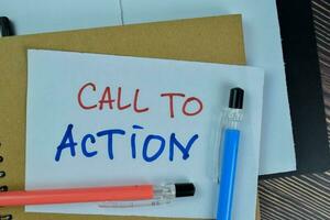 Concept of Call To Action write on sticky notes isolated on Wooden Table. photo