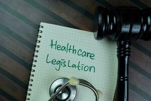 concepto de cuidado de la salud legislacion escribir en un libro con mazo aislado en de madera mesa. foto