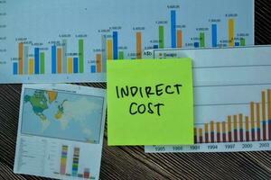 Concept of Indirect Cost write on sticky notes isolated on Wooden Table. photo