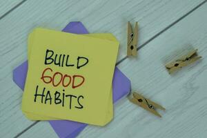 Concept of Build Good Habits write on sticky notes isolated on Wooden Table. photo