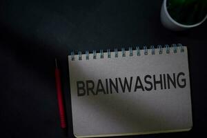 Brainwashing write on a book isolated on Office Desk photo