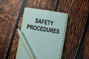 Safety Procedures write on a book isolated on office desk. photo