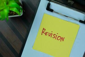 Concept of Revision write on sticky notes isolated on Wooden Table. photo
