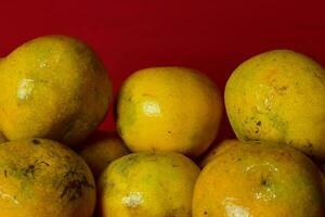 Fresh orange fruit in the red background photo