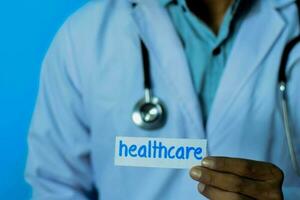 Doctor holding a card with text healthcare. Medical and healthcare concept. photo