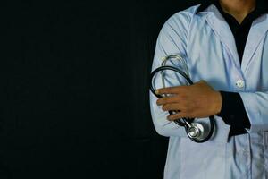 Physician or doctor holding stethoscope. Listening story patient concept. Isolated on black background photo