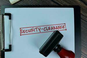 Concept of Security-Clearance write on a paperwork isolated on Wooden Table. photo