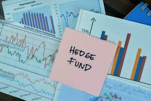 Concept of Hedge Fund write on sticky notes isolated on Wooden Table. photo