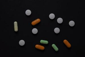 colorful medication and medicine pills, tablets and capsules. Isolated on office desk background. Medical or Healthcare concept photo