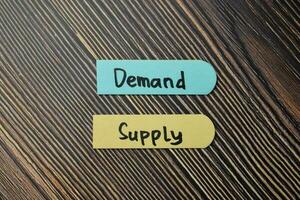 Demand Supply write on sticky notes isolated on office desk. photo