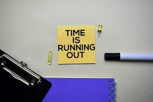 Time Is Running Out text on sticky notes with office desk concept photo