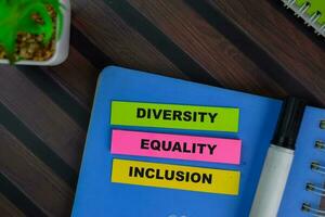 Diversity Equality Inclusion write on sticky notes isolated on Wooden Table. photo