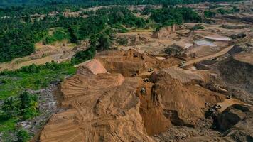 aéreo ver de trabajo de camiones y el excavador en un abierto pozo en oro minería. central sulawesi, Indonesia, marzo 3, 2022 foto