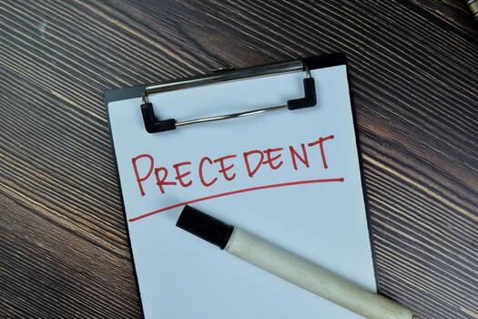 Concept of Precedent write on a paperwork isolated on Wooden Table. photo