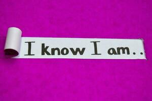 I know I am text, Inspiration, Motivation and business concept on purple torn paper photo