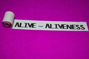 Alive - Aliveness text, Inspiration and positive vibes concept on purple torn paper photo