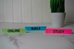 Online Bible Study write on a sticky note isolated on Office Desk. photo