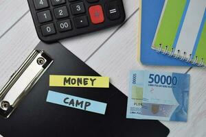 Money Camp text write on sticky notes isolated on office desk. photo