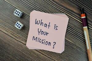 Concept of What is your mission write on sticky notes isolated on Wooden Table. photo