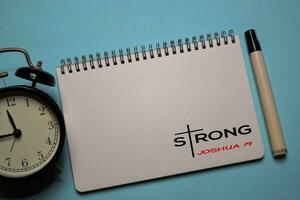 Strong - Joshua One Nine write on a book isolated on office desk. Christian faith concept photo