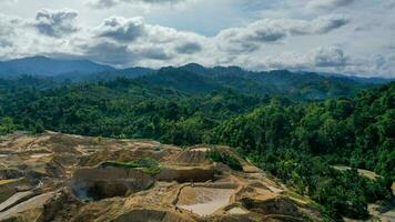 aéreo ver de trabajo de camiones y el excavador en un abierto pozo en oro minería. central sulawesi, Indonesia, marzo 3, 2022 foto