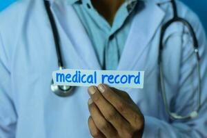 Doctor holding a card with text medical record. Medical and healthcare concept. photo