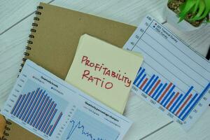 Concept of Profitability Ratio write on sticky notes isolated on Wooden Table. photo