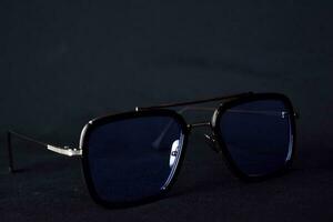 Close-up of retro sunglasses isolated on bokeh black background photo