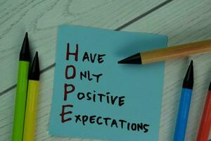 HOPE - Have Only Positive Expectations write on sticky notes isolated on Wooden Table. photo