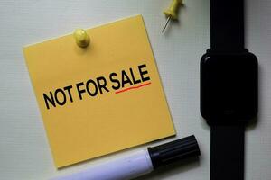 Not For Sale text on sticky notes isolated on office desk photo