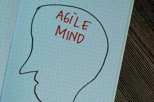 Agile Mind write on a book isolated on Wooden Table. photo