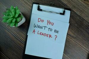 Concept of Do You Want To Be A Leader write on paperwork isolated on Wooden Table. photo