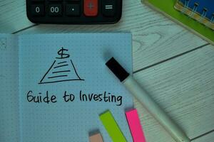 Guide to Investing write on a book isolated on office desk. photo