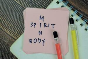 Concept of Spirit, Mind and Body crossword write on sticky notes isolated on Wooden Table. photo