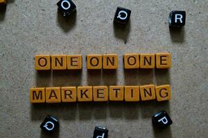 One on One Marketing on wooden cubes. On table background photo