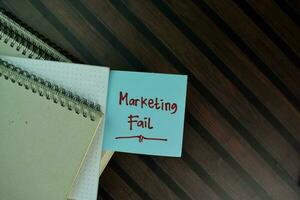 Marketing Fail write on sticky notes isolated on Wooden Table. photo