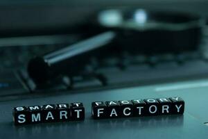 Smart Factory text wooden blocks in laptop background. Business and technology concept photo