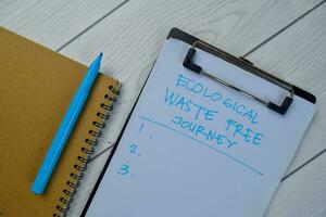 Ecological Waste Free Journey write on a paperwork and supported by additional services isolated on Wooden Table. photo