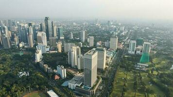 Aerial view of office buildings in Jakarta central business district and noise cloud when sunset. Jakarta, Indonesia, December 21, 2022 photo
