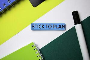 Stick To Plan text on sticky notes with office desk concept photo