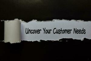 Uncover Your Customer Needs write on white and black torn paper photo